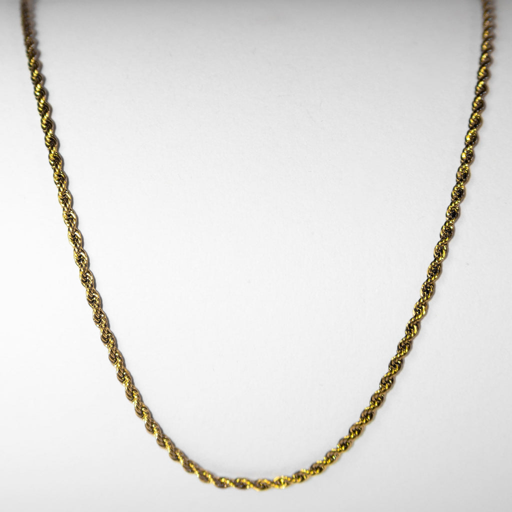 Gold rope chain necklace with twisted links photographed on white background
