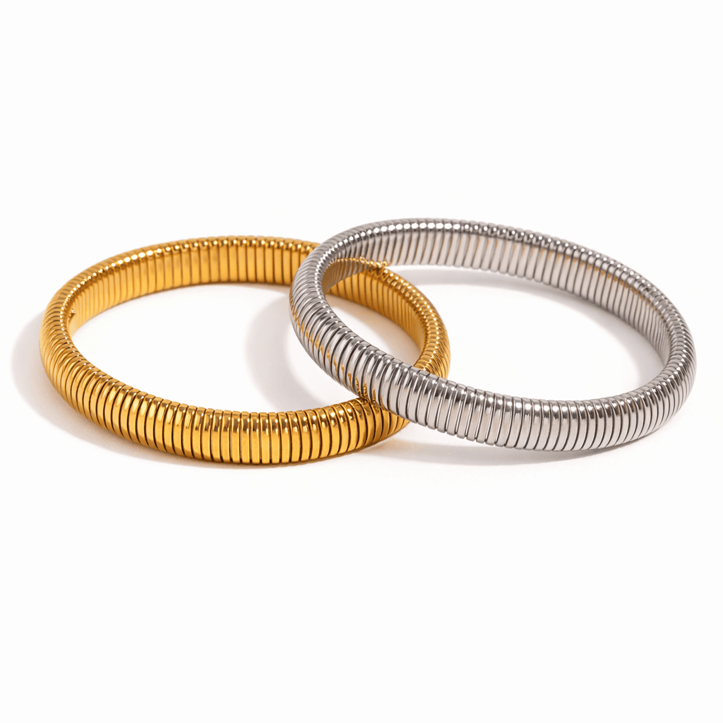 Gold and silver ribbed bangle bracelets with a minimalist modern design on a white background

