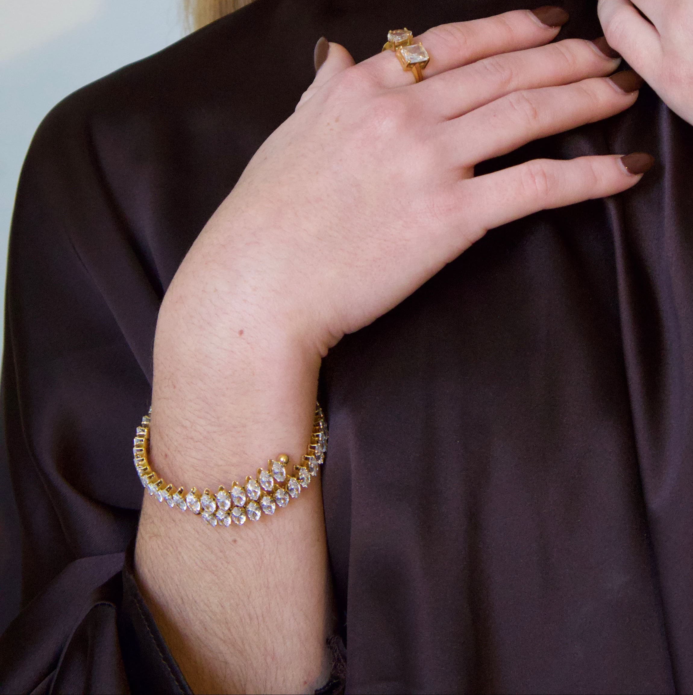 Gold bracelet featuring a structured row of marquise-cut clear crystals
