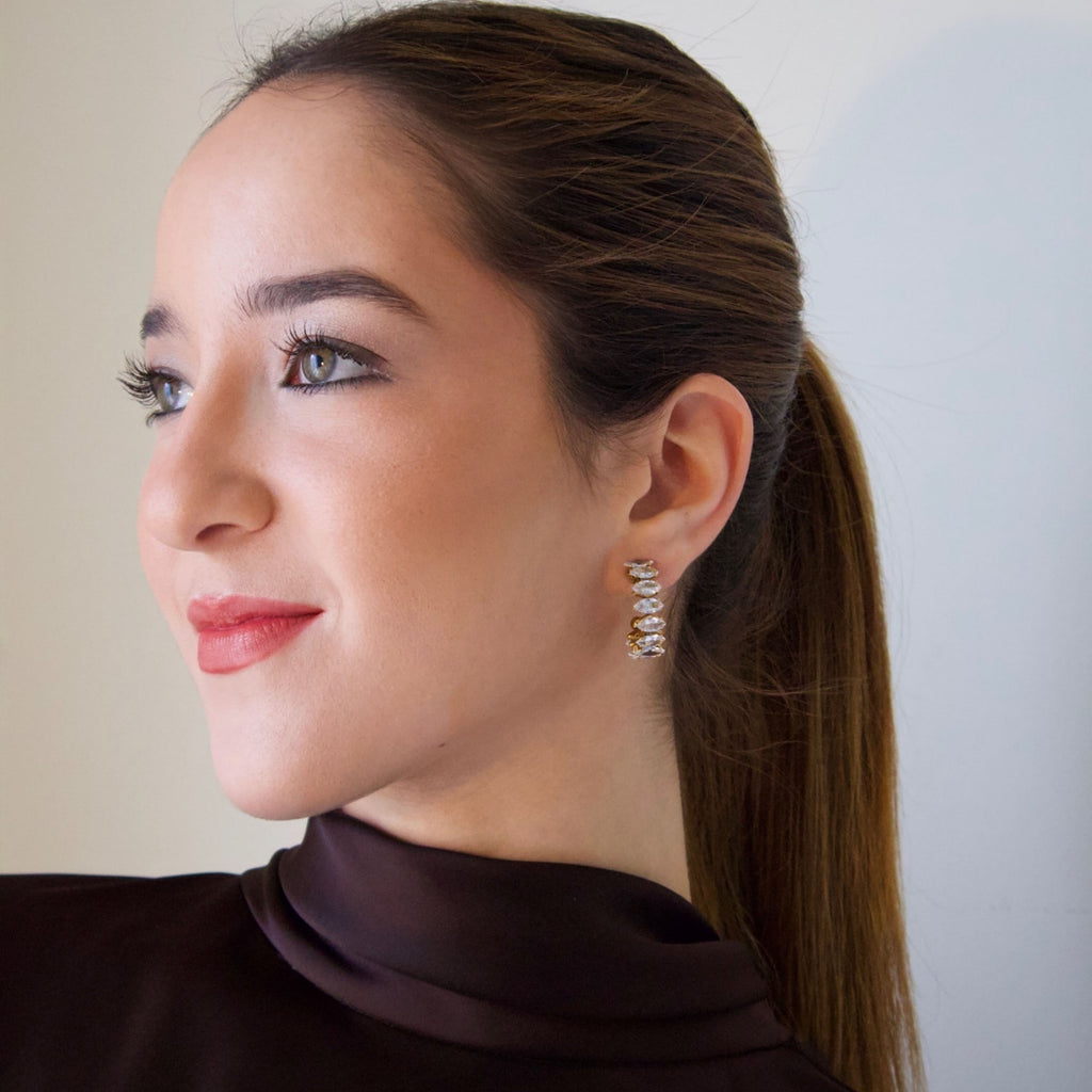 Model wearing gold crystal drop earrings with a refined vertical and contemporary design
