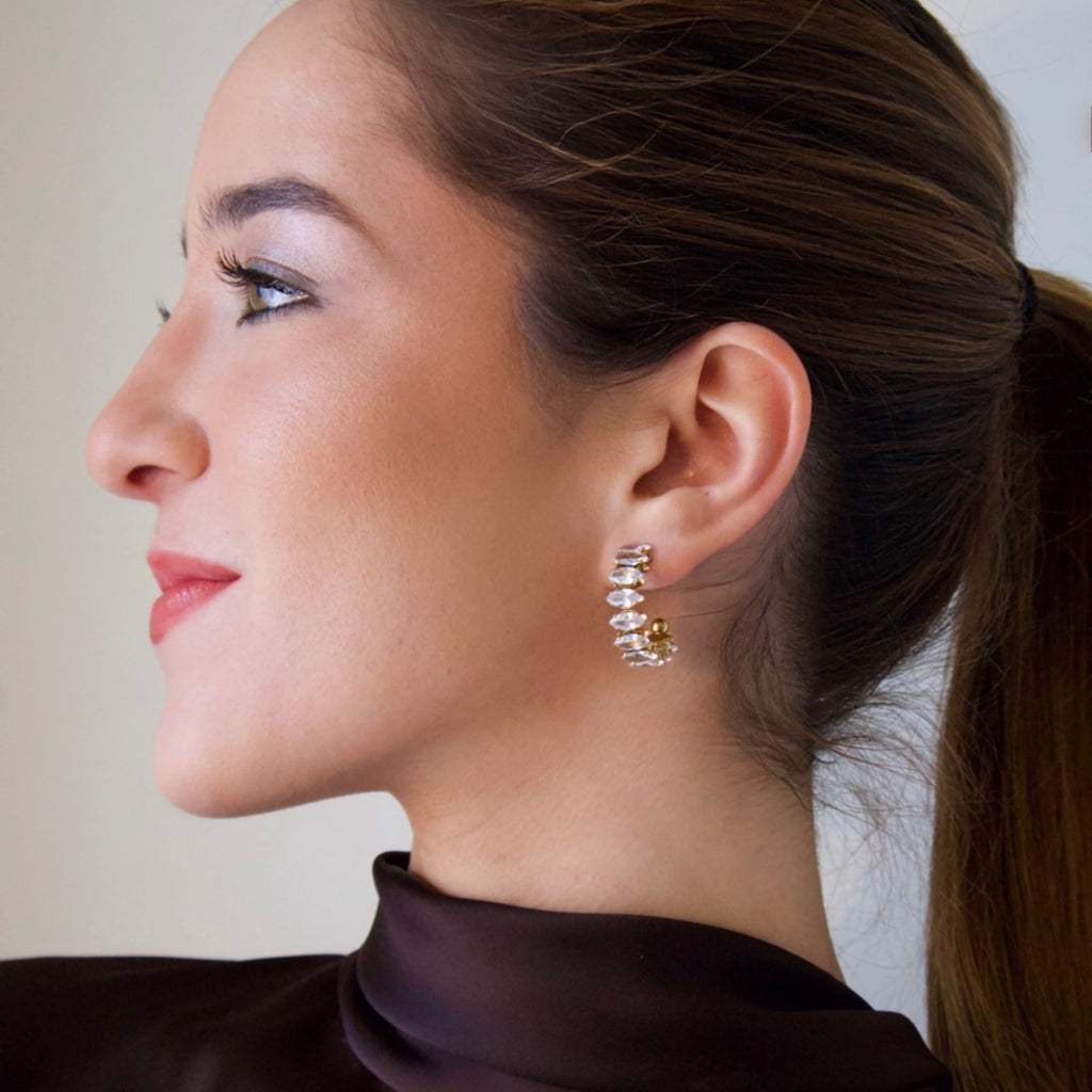 Model wearing gold crystal drop earrings with a refined and contemporary design
