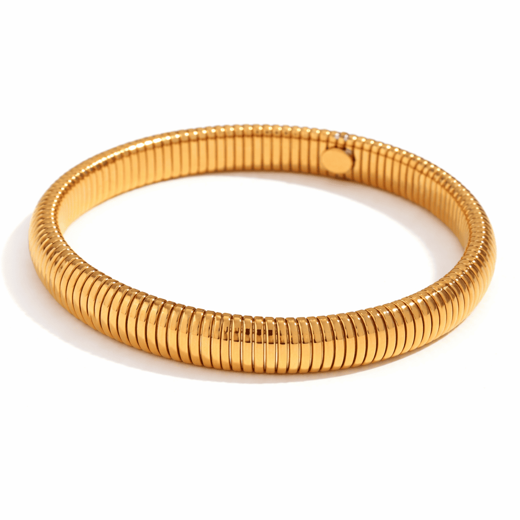 Minimalist gold bangle bracelet with ribbed texture on a white background
