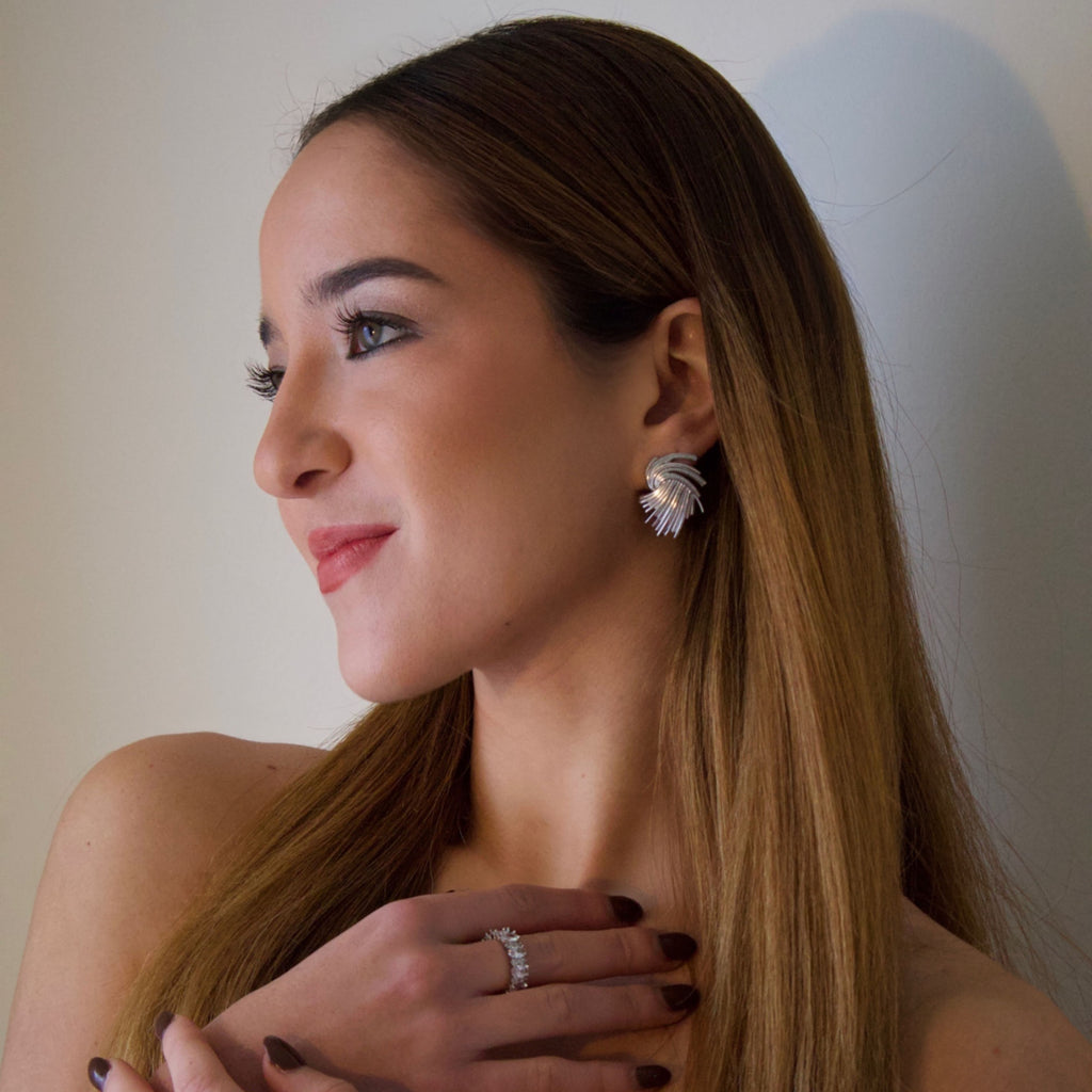 Model wearing sculptural silver statement earrings with organic contemporary design
