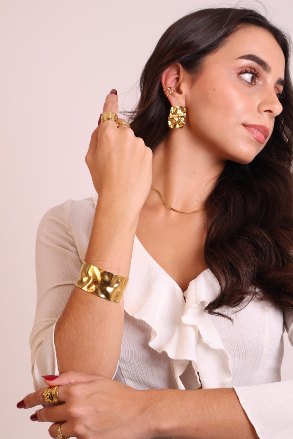 Textured gold cuff bracelet with hammered finish photographed on wrist
