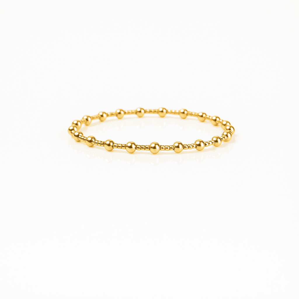 Delicate gold beaded bracelet featuring polished round beads and minimalist design, modern stainless steel jewelry piece on a white background.